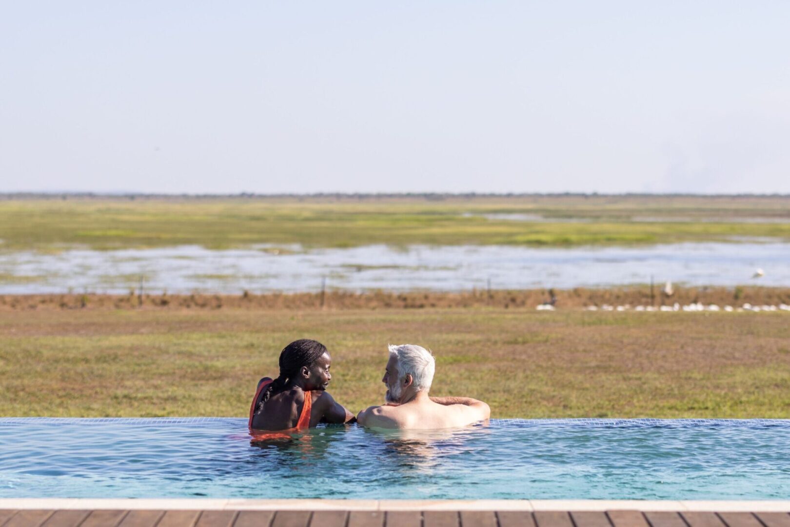 2 people enjoying the infinity pool at Finniss River Lodge as part of our Finniss River Taste Safari.